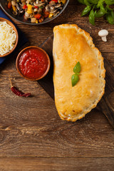 Wall Mural - Italian calzone with mushrooms and ham. Top view.