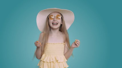 happy young white caucasian girl with long hair yelow dress and summer hat laughing into camera. blo