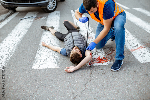 Fotografía Man applying first aid to the injured bleeding person, wearing tourniquet on the