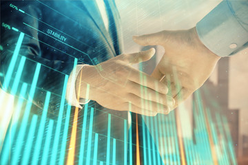 Double exposure of financial graph on cityscape background with two businessman handshake. Concept of stock market deal