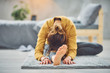 © chika_milan - Caucasian brunette stretching leg while sitting on the rug in bedroom.