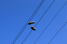 A Pair Of Shoes Hanging On The Power Line Cable.