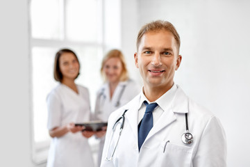 Canvas Print - healthcare, medicine and profession concept - smiling male doctor in white coat at hospital