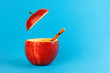 Health Red Cut Apple recyclable paper straw juice drink idea concept on blue background