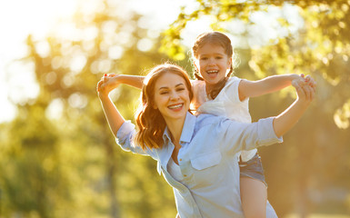 Wall Mural - happy family mother and child daughter in nature   in summer  .