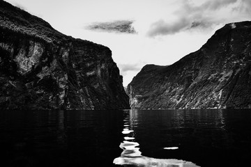 Wall Mural - Stunning Geirangerfjord seen by boat trip in Sunnmore region, Norway, one of the most beautiful fjords in the world, included on the UNESCO World Heritage. Black and white image.