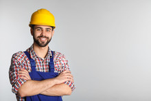 Portrait Of Construction Worker In Uniform On Light Background, Space For Text
