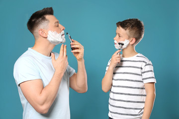 Sticker - Dad shaving and son imitating him on blue background