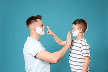 Sticker - Happy dad and son with shaving foam on faces against blue background