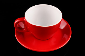 Sticker - Empty red cup and saucer on a black background