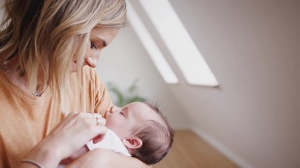 Wall Mural - Loving Mother Holding Sleeping Newborn Baby Son At Home In Loft Apartment