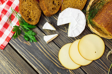 Fresh bread with green, cheese camambert on wooden background. Healthy food lifestyle, vegetarian concept