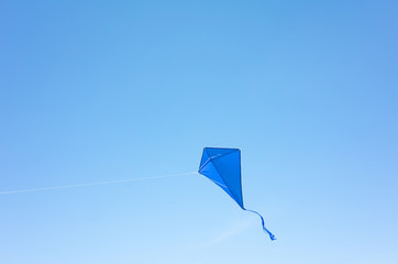 a blue kite soars in a cloudless sky. the concept of freedom, summer hobbies, entertainment in natur