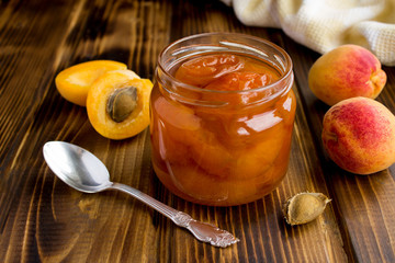 Wall Mural - Apricot jam and apricots on the brown wooden  background.Closeup.