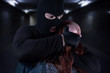 © syberianmoon - Scared young victim woman caught by gangster criminal in dark underground tunnel. Bandit in black mask and gloves covering young woman's mouth with his hand. Kidnapping, criminal, terrorist concept.