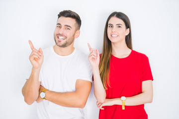 Young beautiful couple together over white isolated background with a big smile on face, pointing with hand and finger to the side looking at the camera.