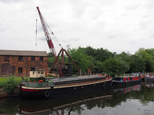 Barges And Houseboats On The Aire And Calder Navigation Canal At Stourton Leeds With And Old Crane And The Historic Thwaite Mills Building