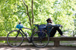 © Westend61 - Young man with bicycle relaxing on a bench