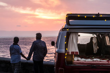 Senior Couple Traveling In A Vintage Van, Watching Sunset At The Sea