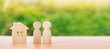 © Andrii Yalanskyi - Two wooden figures of people and a house on a nature background. concept of affordable housing, mortgages for buying a home for young families and couples. Family nest. Copy space. Banner