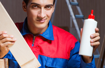 Wall Mural - Young man gluing wood pieces together in DIY concept