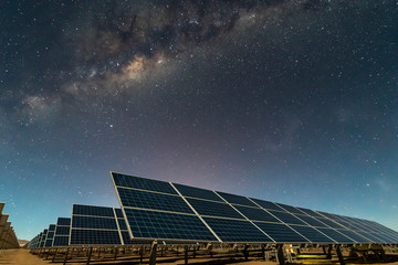 Solar Energy Panels view, a nice technology blue pattern at Atacama Desert arid lands. The solar modules going to the infinity with the Milky Way trying to get energy from the stars on the night sky 