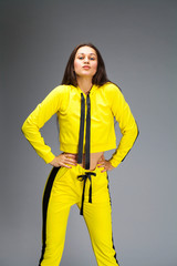 Sticker - Portrait of a young beautiful brunette woman in yellow tracksuit