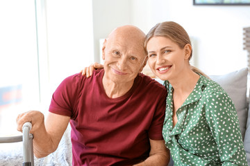 Wall Mural - Young woman visiting her elderly father in nursing home