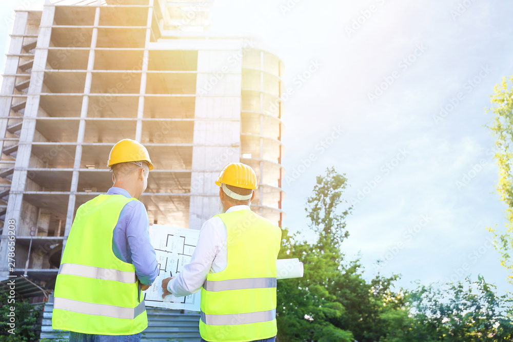 Architects discussing project of building outdoors