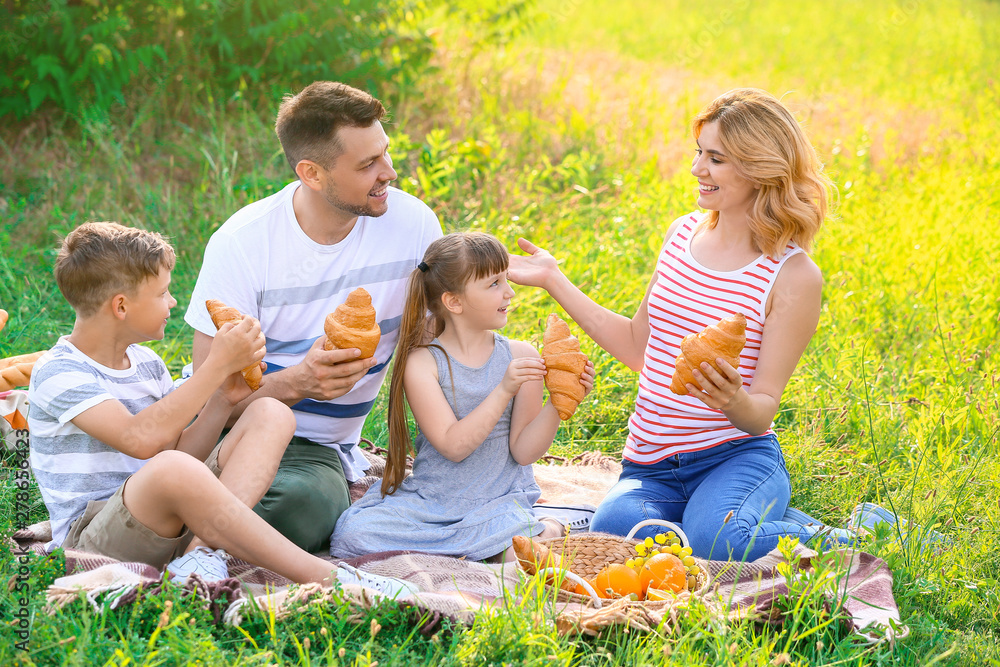Happy family on summer picnic in park