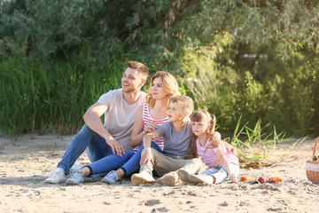 Wall Mural - Happy family on summer picnic near river