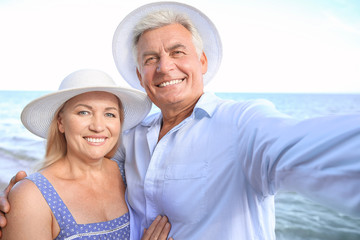 Poster - Happy mature couple taking selfie at sea resort