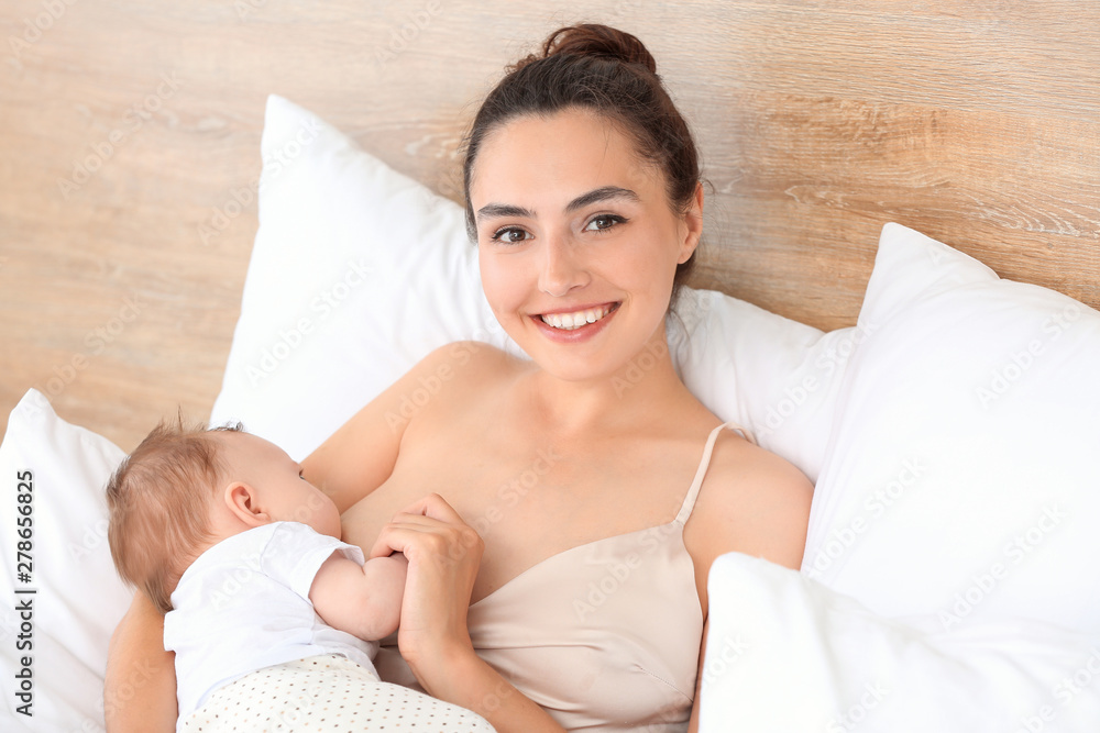Young woman breastfeeding her baby at home