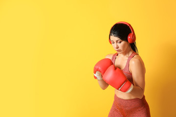 Sticker - Sporty female boxer with headphones on color background