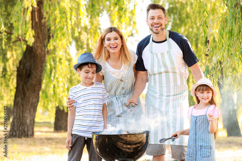 Fotografía Happy family cooking tasty food on barbecue grill outdoors