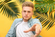 © Pixel-Shot - Stylish young man and tropical leaves on color background