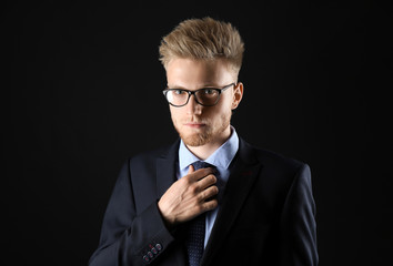 Wall Mural - Stylish young man in formal clothes on dark background