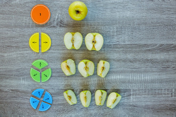 Wall Mural - Сolorful math fractions and apples as a sample on wooden background or table. Interesting creative funny math for kids. Education, back to school concept. Geometry and mathematics materials.