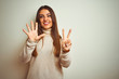 © Krakenimages.com - Young beautiful woman wearing winter turtleneck sweater over isolated white background showing and pointing up with fingers number seven while smiling confident and happy.