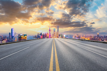 Empty asphalt highway and modern city skyline in Shanghai at sunset,China