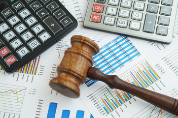 Arbitration concept, wooden judge gavel and calculators on financial documents