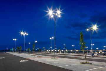 Wall Mural - big modern empty parking lot with bright LED street lights at night