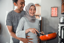 Husband Hold His Wife Belly While Cooking In The Kitchen