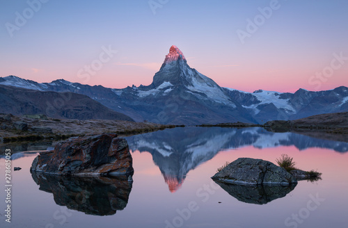 Leinwand Poster  The famous Matterhorn reflected in the Stellisee during a pink dawn
