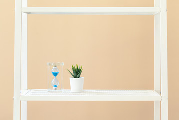 Poster - White bookshelf with plant in pot against beige background