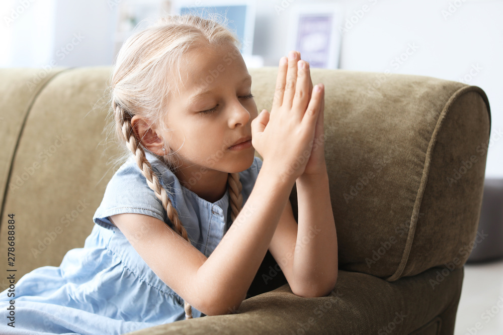Little girl praying at home