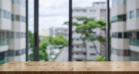 Empty wood table top and blur glass window wall building banner background