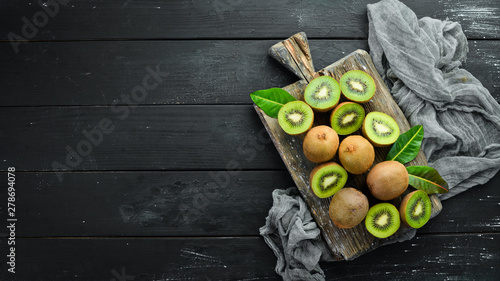 Fresh kiwi and green leaves on the table Poster Mural XXL