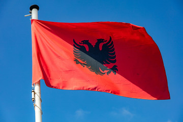 Albanian flag waving against clear blue sky