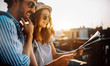 © NDABCREATIVITY - Happy young couple of travellers holding map in hands